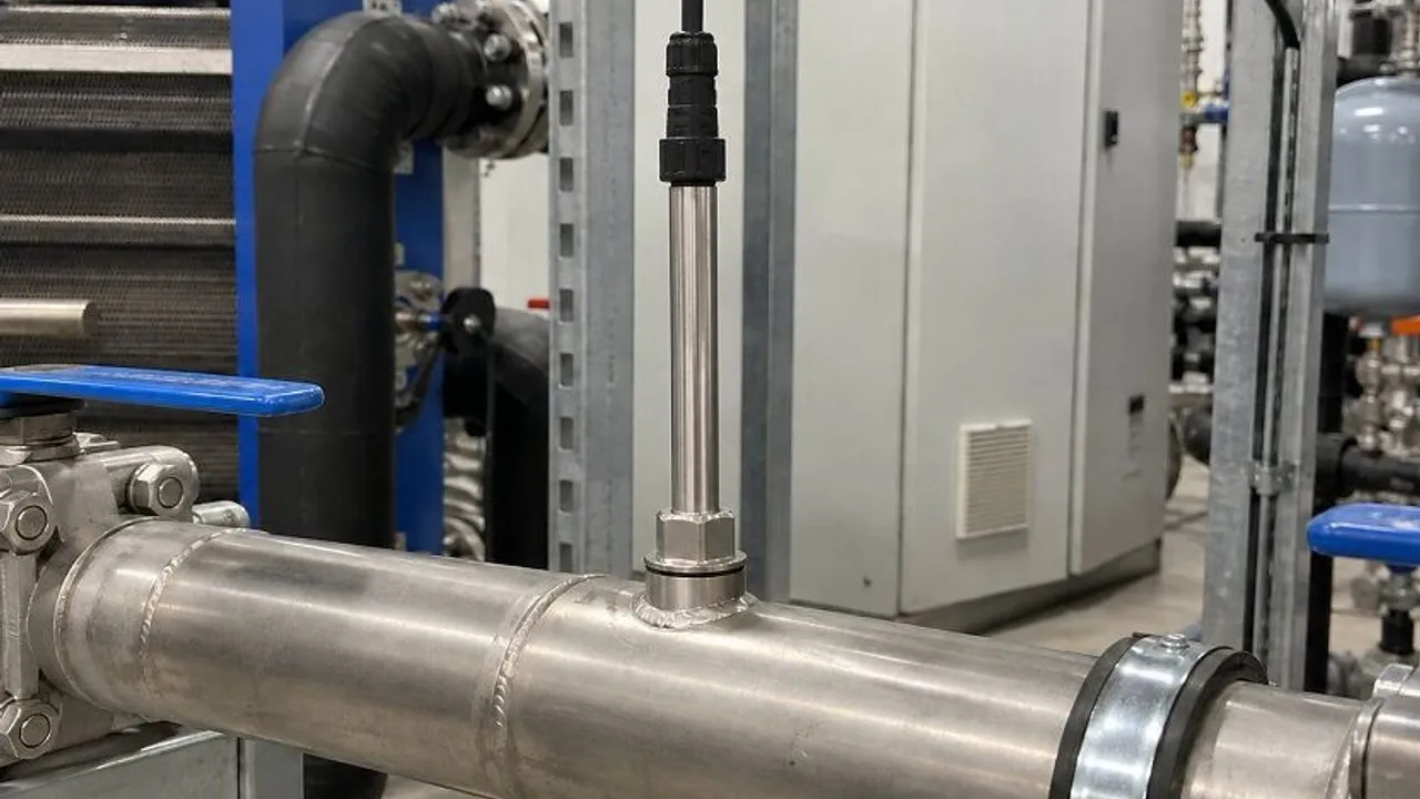 Stainless-steel industrial pipe with a sensor probe and blue-handled valve