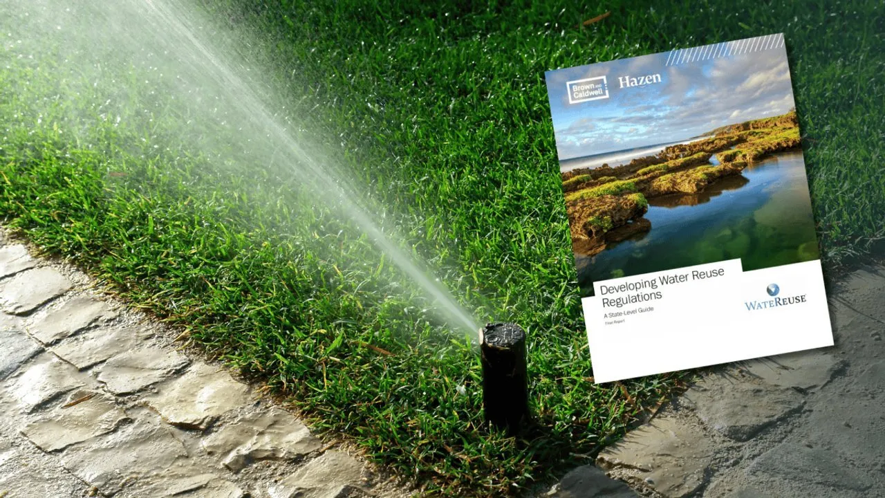 A lawn sprinkler sprays water beside a water reuse regulations booklet on grass.