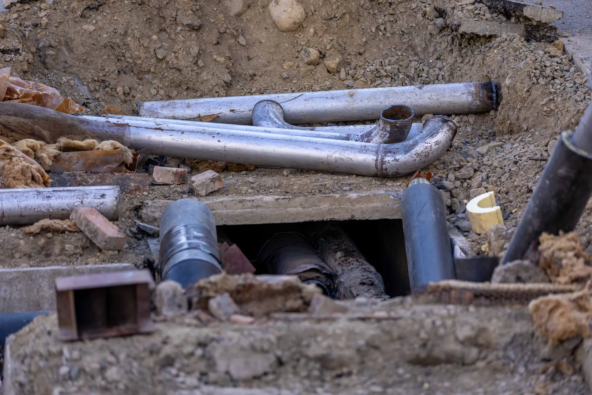 Old metal pipes laid bare in a dug-up street