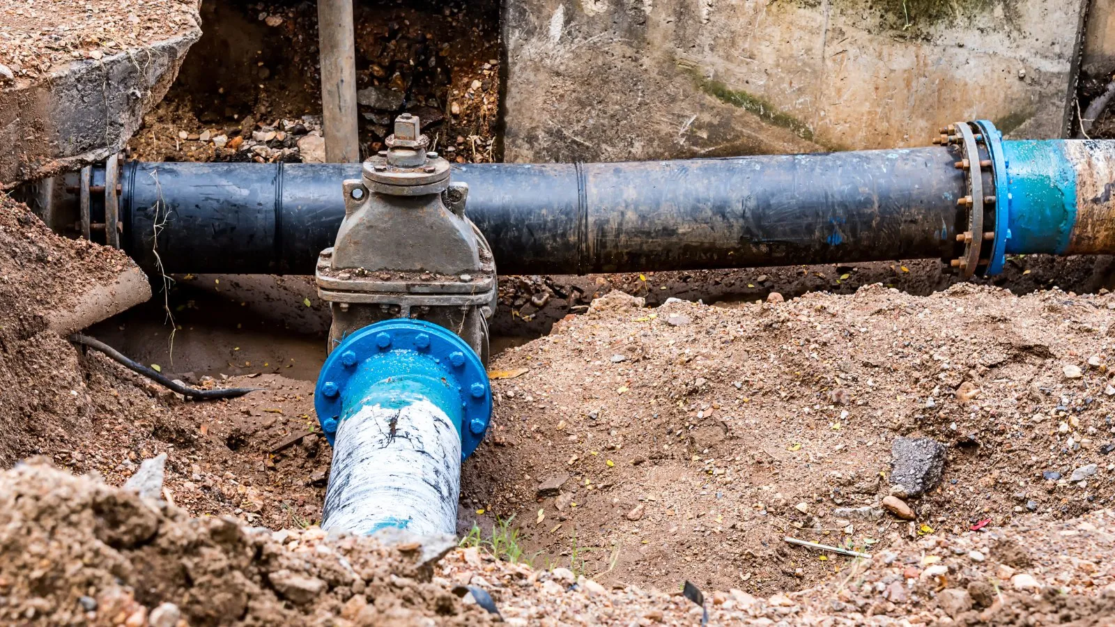 An old water main with a valve exposed in a trench during pipe work