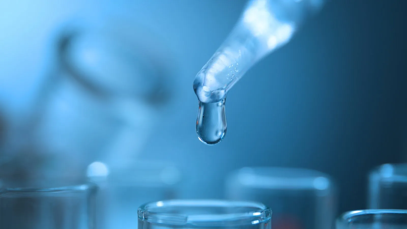 A pipette dropping water into a laboratory test tube