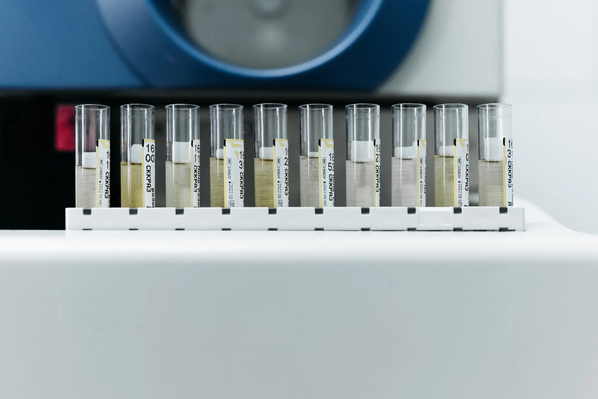 A row of labelled water sample tubes in front of a laboratory analyser